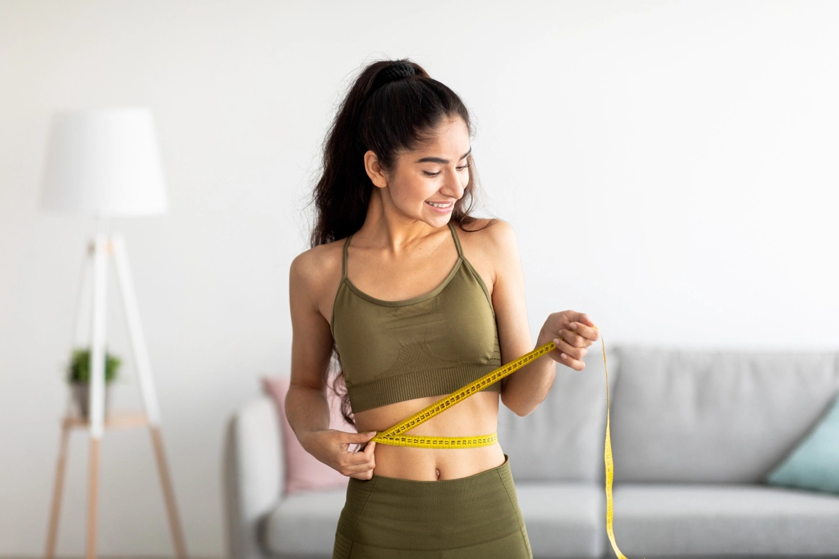 Woman Measuring Waist After Weight Loss Treatment